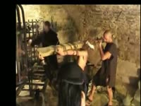 Two nasty sadistic dudes crucifying a naked girl